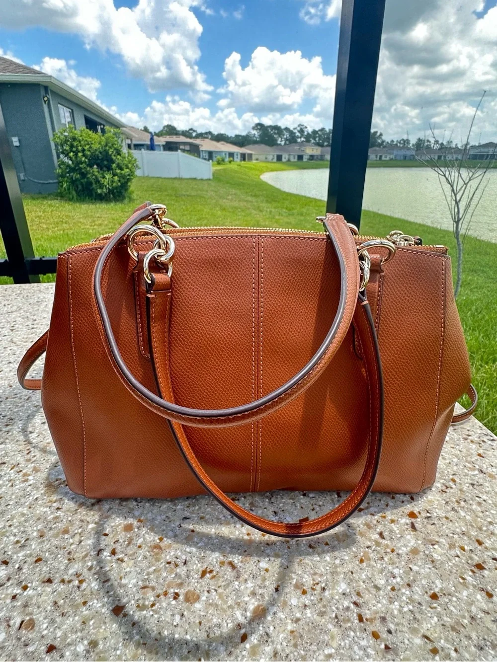 Coach Christie Carryall in a brown, textured leather with gold-tone hardware